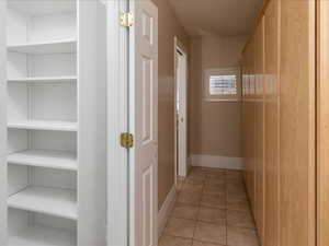 Hallway with light tile patterned floors