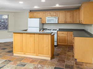 Kitchen with a center island with sink and white appliances