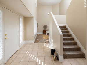 Entryway with a high ceiling and light tile patterned floors