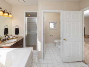 Full bathroom with tile patterned flooring, vanity, separate shower and tub, toilet, and a bidet