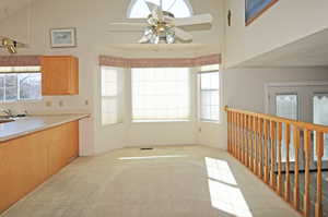 Kitchen with ceiling fan, light colored carpet, plenty of natural light, and sink