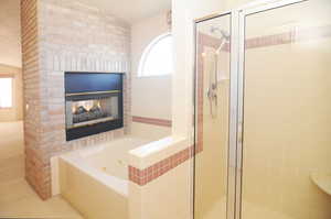 Bathroom with plus walk in shower and a fireplace