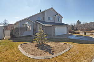 View of front of property featuring a garage and a front yard