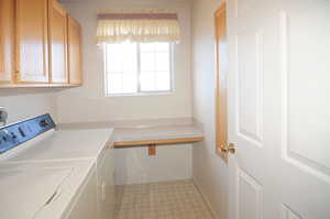 Clothes washing area with washer and clothes dryer and cabinets