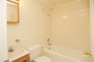 Full bathroom featuring vanity, tiled shower / bath, and toilet