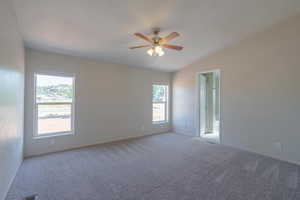 Unfurnished room featuring lofted ceiling, light colored carpet, and ceiling fan