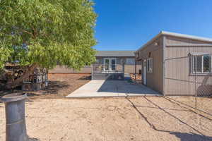 Back of property featuring a deck and a patio area