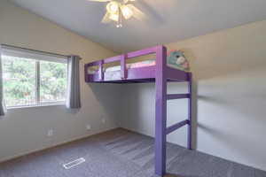 Unfurnished bedroom featuring lofted ceiling, ceiling fan, and carpet