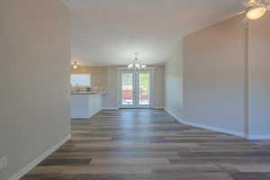 Interior space with a notable chandelier, dark hardwood / wood-style floors, and french doors