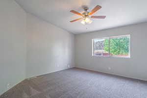 Unfurnished room featuring carpet and ceiling fan