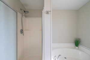 Bathroom featuring shower with separate bathtub