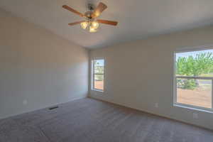 Carpeted empty room featuring ceiling fan