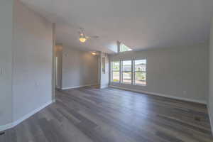 Unfurnished room featuring lofted ceiling, dark hardwood / wood-style floors, and ceiling fan