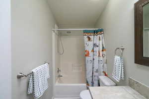 Full bathroom featuring vanity, toilet, and shower / bath combo with shower curtain