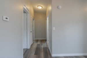 Hall with dark hardwood / wood-style floors