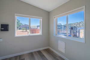 Spare room featuring dark hardwood / wood-style floors and vaulted ceiling