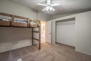 Unfurnished bedroom featuring lofted ceiling, a closet, ceiling fan, and carpet flooring