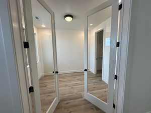 Hallway with visible vents, recessed lighting, light wood-type flooring, and baseboards