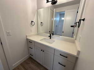 Bathroom with baseboards, wood finished floors, and vanity