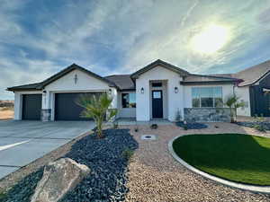 Single story home with stucco siding, concrete driveway, a garage, stone siding, and a tiled roof