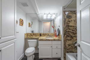 Full bathroom featuring vanity, hardwood / wood-style floors, shower / bathing tub combination, and toilet