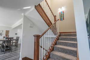 Staircase featuring crown molding and hardwood / wood-style floors