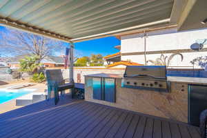 Wooden terrace featuring a fenced in pool, area for grilling, grilling area, and a patio area