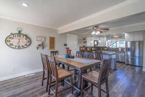 Dining space with crown molding, dark wood-type flooring, and a textured ceiling