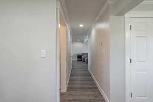 Corridor featuring ornamental molding and dark hardwood / wood-style floors