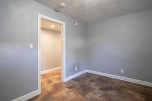 Unfurnished room featuring a textured ceiling