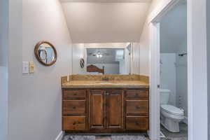 Bathroom with vanity, ceiling fan, and toilet