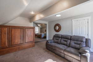 Carpeted living room with lofted ceiling and a textured ceiling