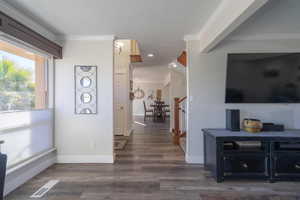 Interior space with crown molding and dark hardwood / wood-style floors