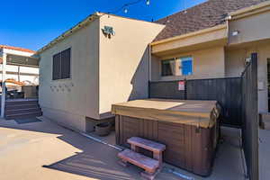 View of home's exterior with a hot tub and a patio