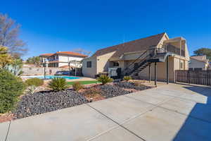 Rear view of house featuring a fenced in pool and a patio