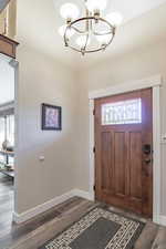 Foyer featuring dark hardwood / wood-style floors and a chandelier