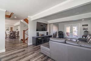 Living room featuring french doors, ornamental molding, dark wood-type flooring, and a textured ceiling