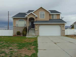 View of front of home featuring a front lawn and a garage