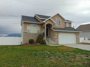 View of front of property with a front yard and a garage