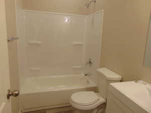 Full bathroom featuring toilet, shower / washtub combination, vanity, and wood-type flooring