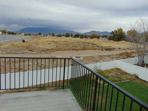 Wooden deck with a mountain view and a yard