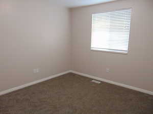 Unfurnished room with dark colored carpet