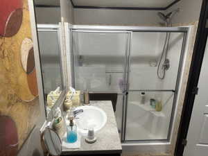 Bathroom featuring a shower with door and vanity