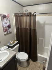 Full bathroom featuring toilet, tile patterned floors, shower / bathtub combination with curtain, and vanity