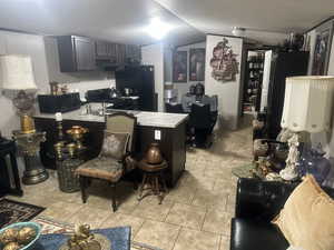 Kitchen with lofted ceiling, light tile patterned floors, and black appliances