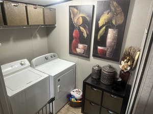 Laundry area featuring washing machine and dryer and light tile patterned floors