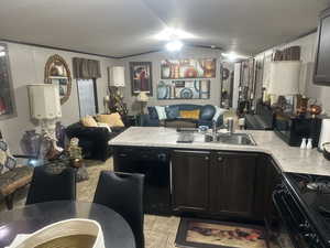 Kitchen with lofted ceiling, sink, light tile patterned floors, and black appliances