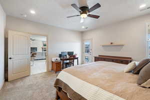 Carpeted bedroom with ceiling fan and a textured ceiling