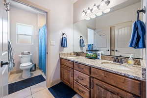 Bathroom with vanity, tile patterned floors, and toilet