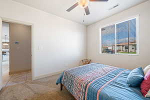 Carpeted bedroom featuring ceiling fan